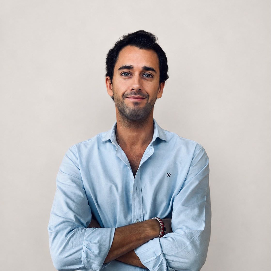 Ricardo, un componente del equipo Bloom® posando sonriente y cruzado de brazos